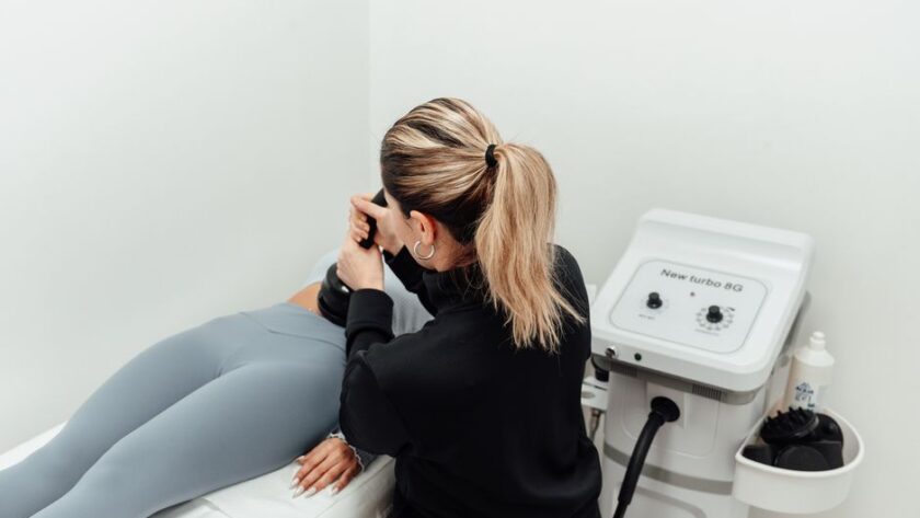Een persoon die geniet van een massage met moderne apparatuur voor spierherstel en ontspanning.